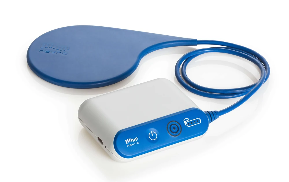 The Nevro charger: a flat blue charging coil connected by a cord to a small white and blue control unit